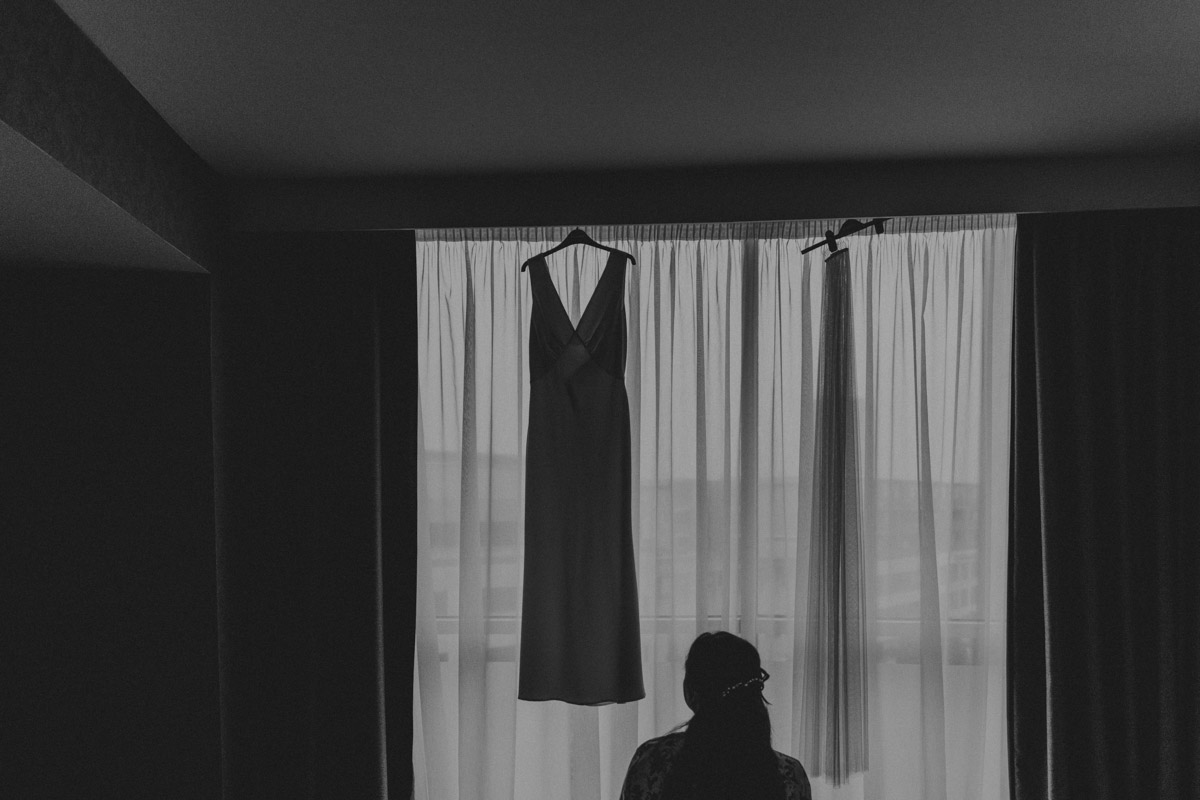 Morning wedding preparation, wedding dress in a window black and white image