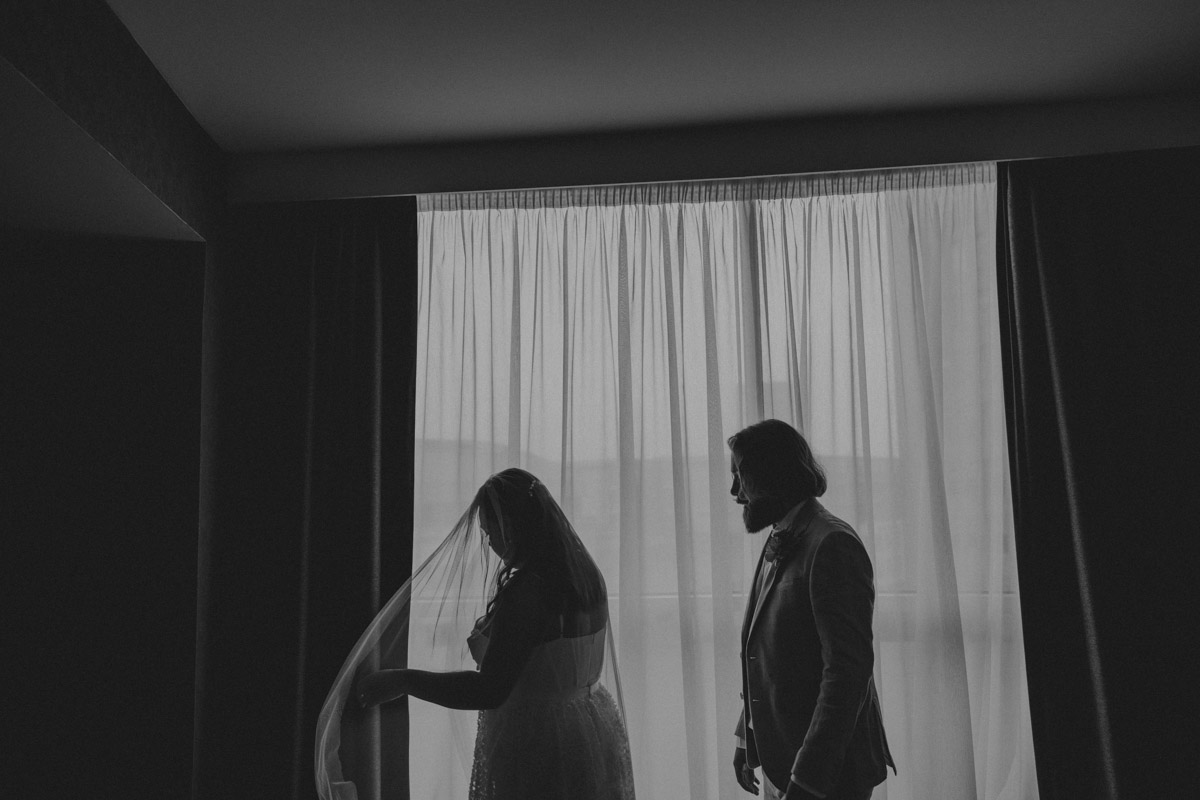 Morning wedding preparations, bride and groom windo silhouette