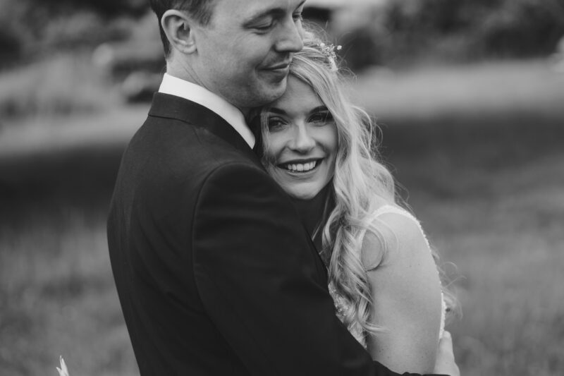 Bride and groom portrait in a field black and white